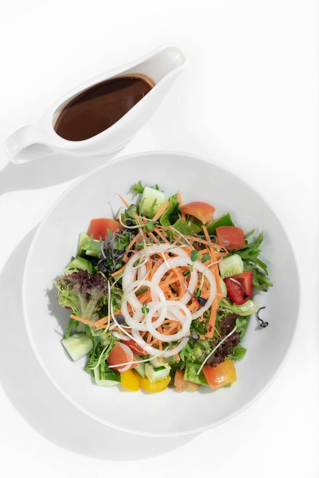 fresh organic mixed vegetable vegan Garden Salad with Vinaigrette sauce on white table