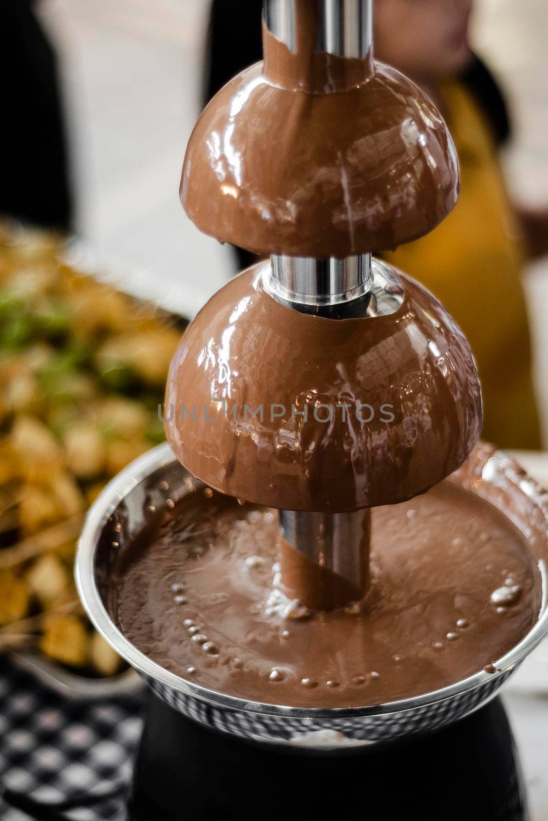 chocolate fountain catering machine with fruit skewers on buffet table by jackmalipan