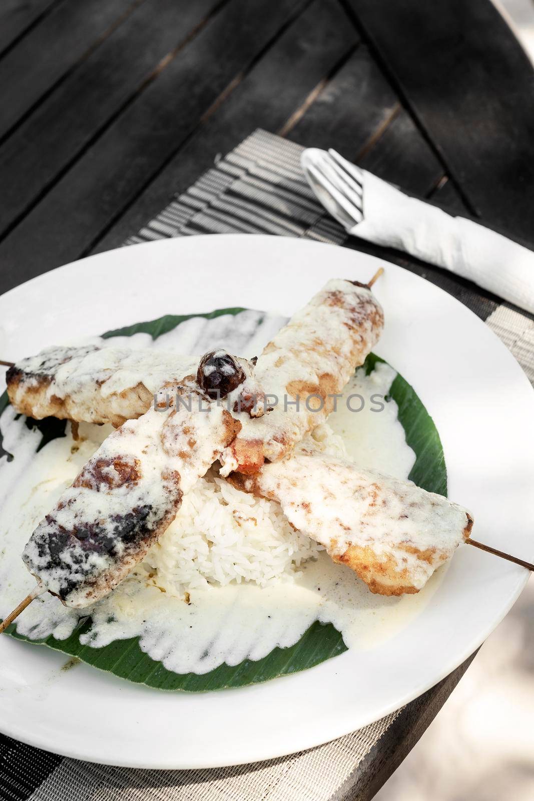fish skewers with creamy coconut sauce and rice in vietnam by jackmalipan