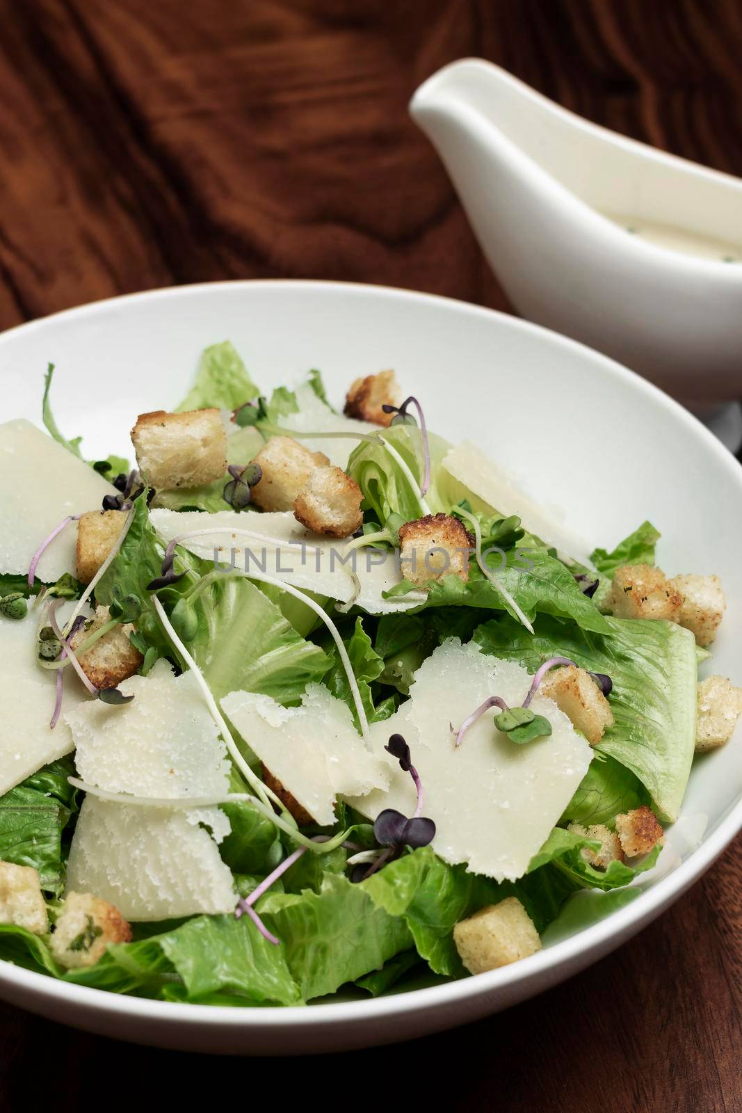 caesar salad with parmesan cheese and croutons on restaurant table

