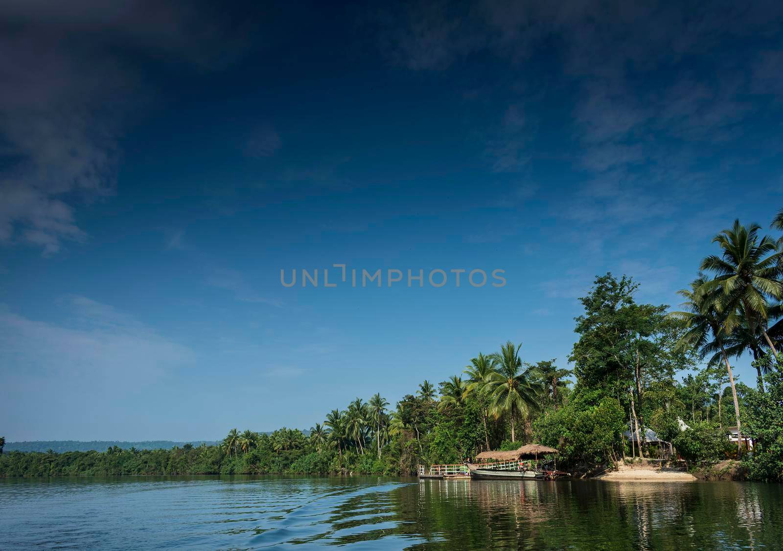 traditional jungle boat at pier on tatai river in cambodia  by jackmalipan