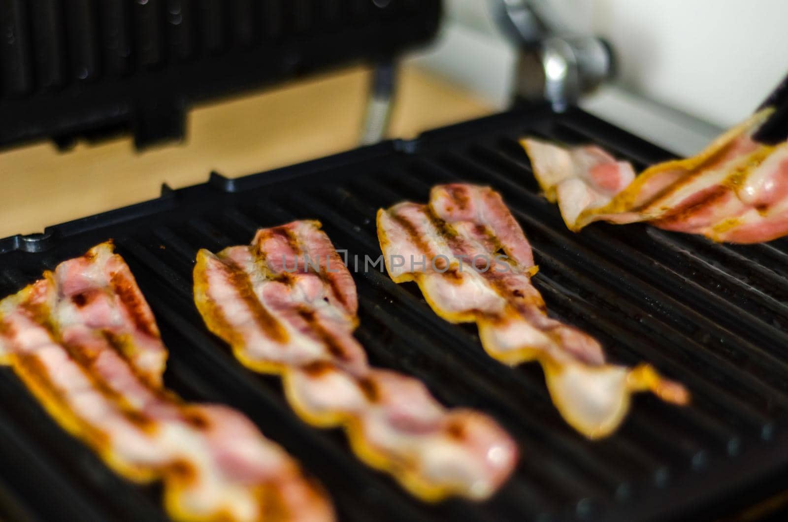 thin slices of delicious bacon fried on the grill, crispy and delicate meat by Q77photo
