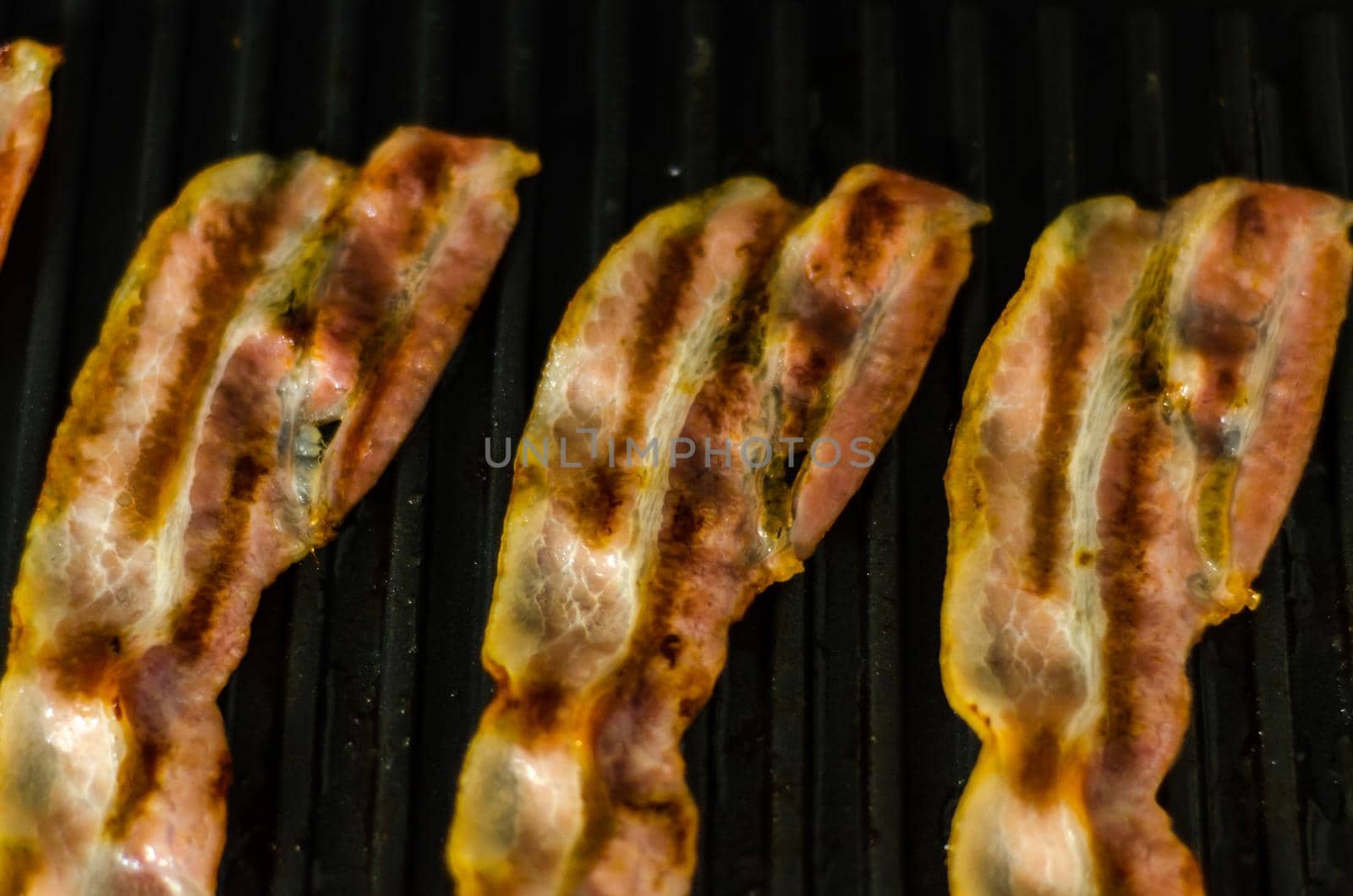 thin slices of delicious bacon fried on the grill, crispy and delicate meat by Q77photo