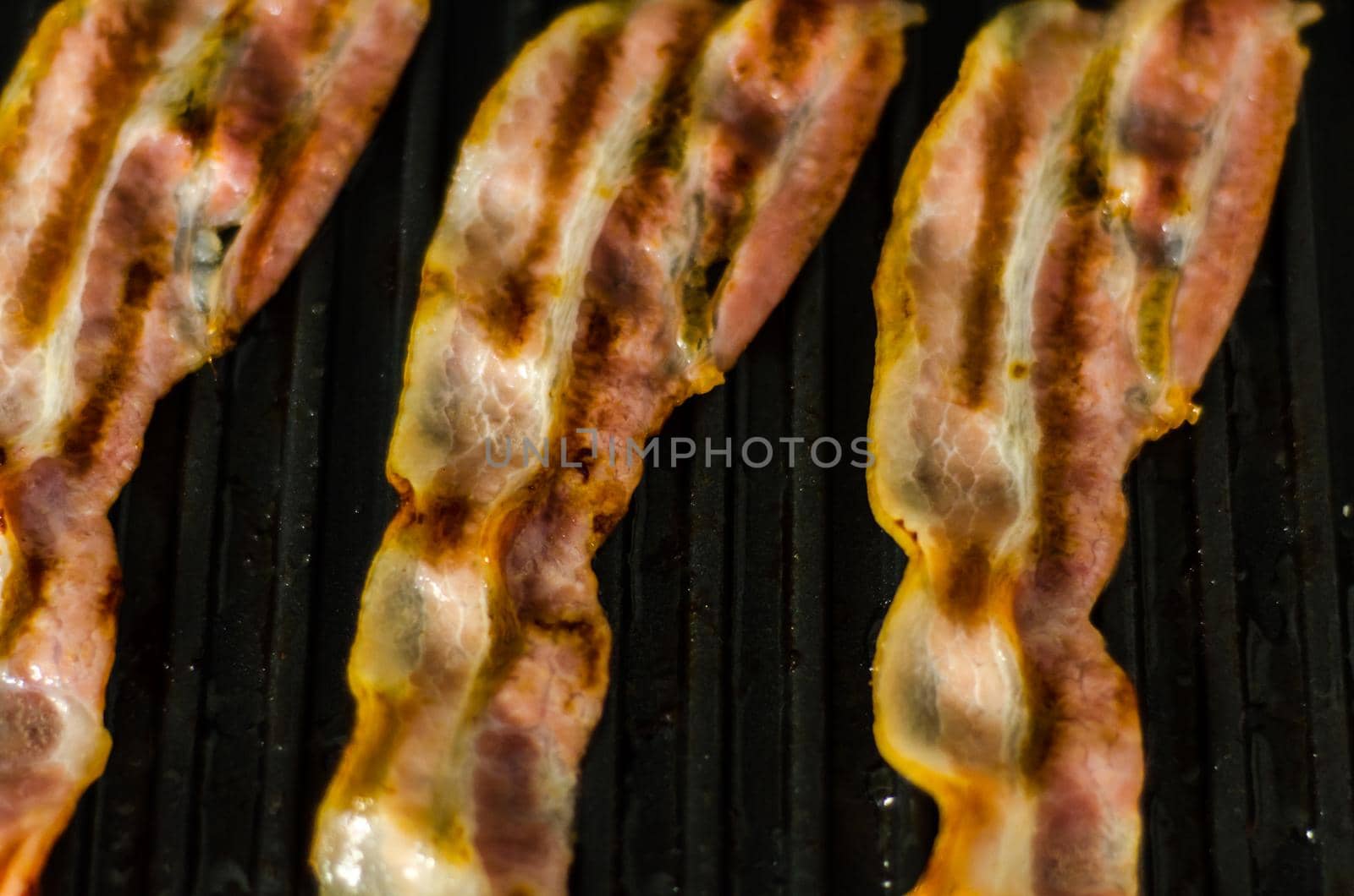 thin slices of delicious bacon fried on the grill, crispy and delicate meat by Q77photo