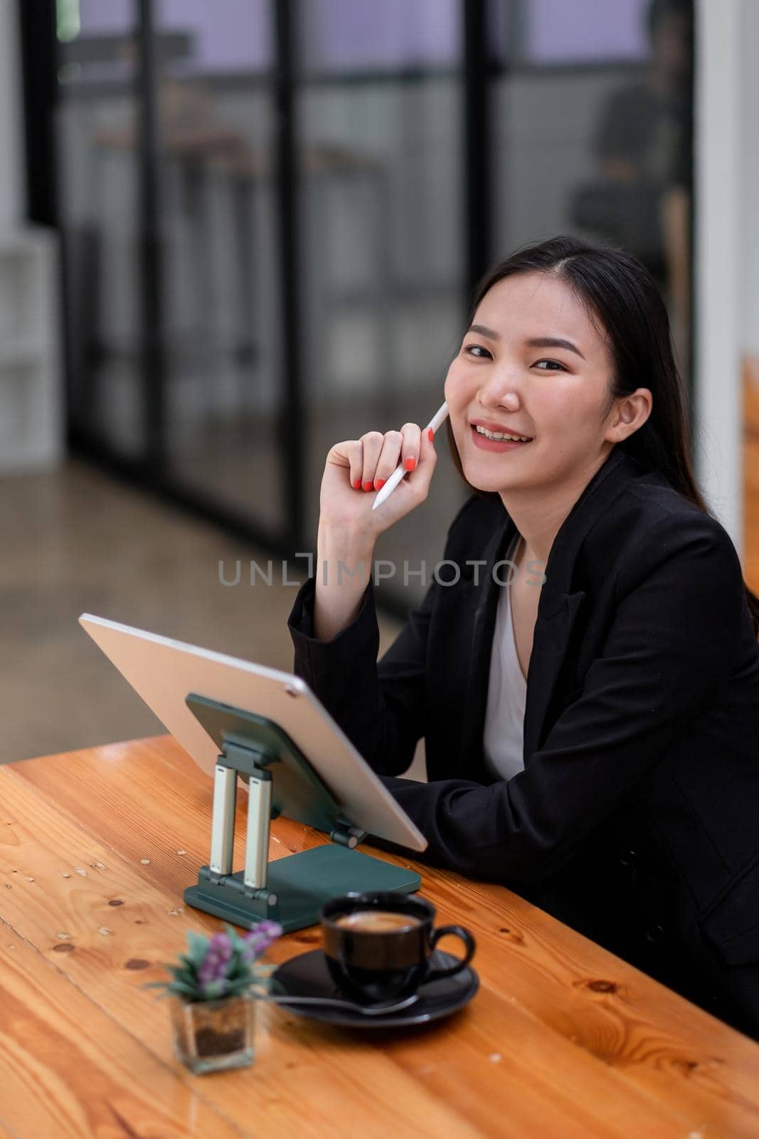 Portrait Of Asian Businesswoman Working with digital tablet at cafe shop by nateemee