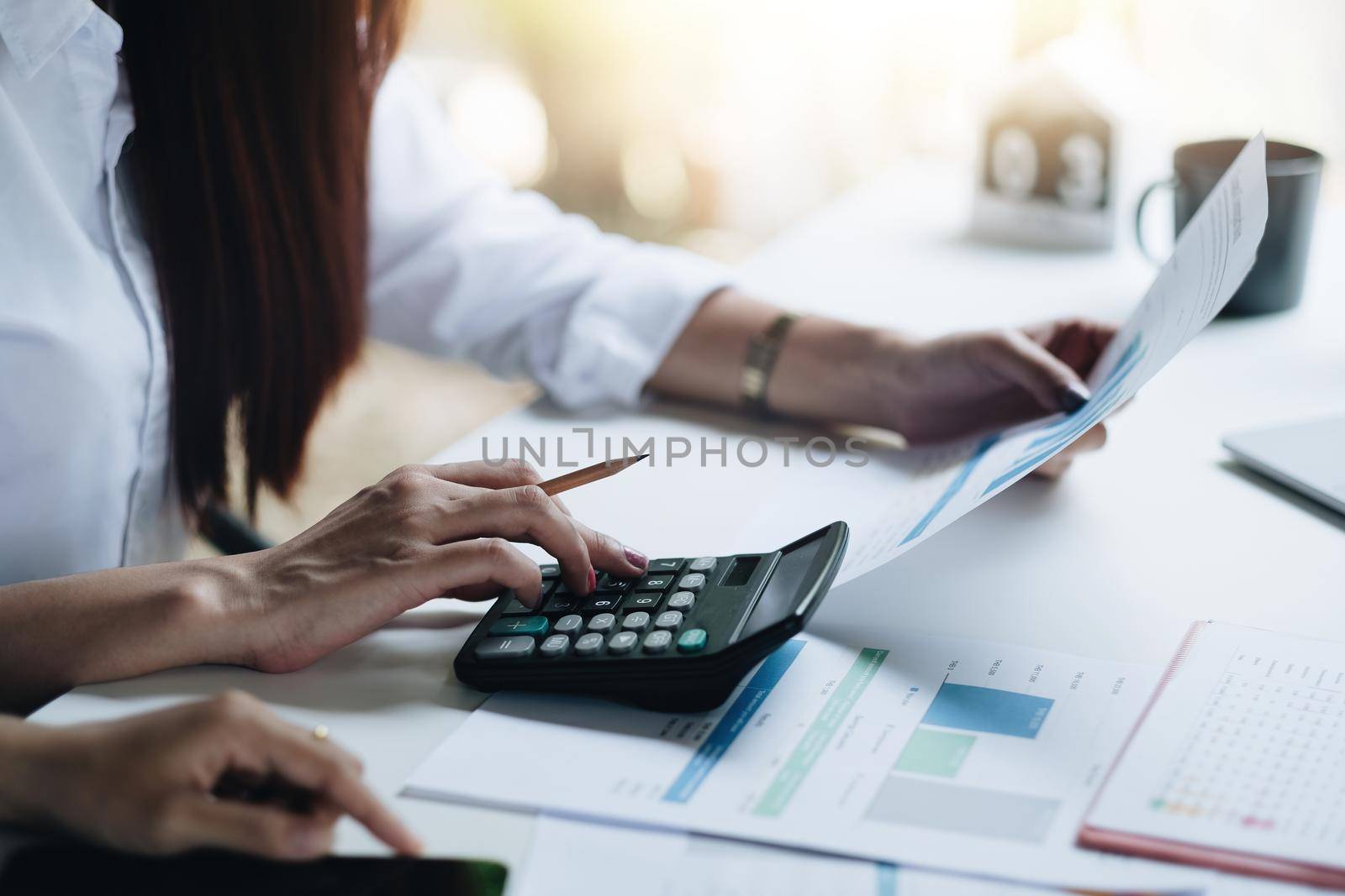 close up hand of accountant working on desk using calculator for calculate finance report in office. by nateemee