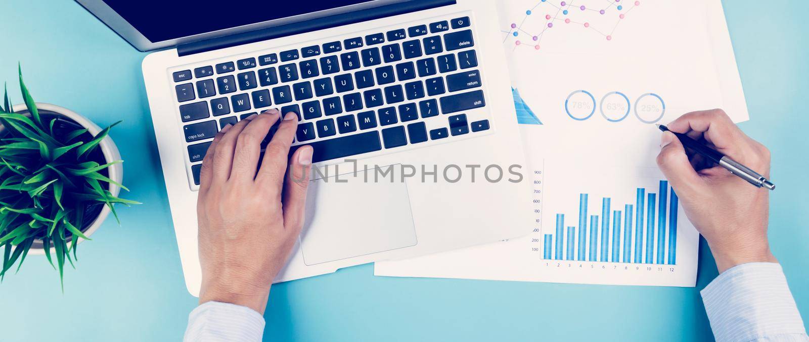 Hand of businessman looking documents report statistic financial with graph and chart and laptop computer on desk, finance and invest, digital marketing, business and communication concept. by nnudoo