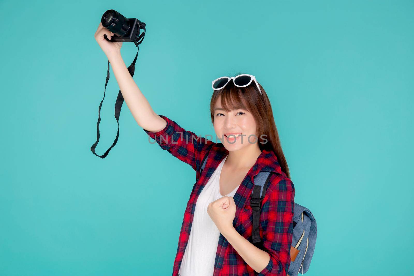 Beautiful young asian woman cheerful and enjoy travel trip summer isolated on blue background, asia girl having activity hobby take a photo holding camera, tourist journey in vacation and holiday. by nnudoo