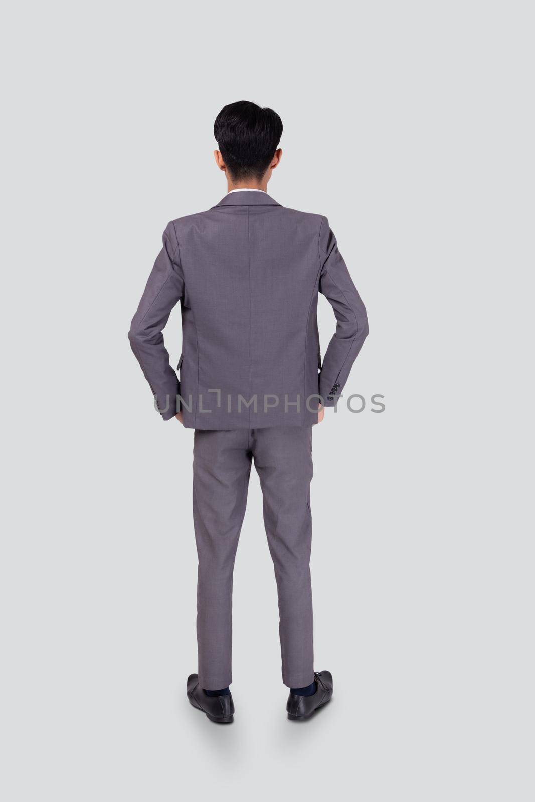 Rear view of young asian businessman in suit hand in pocket with confident isolated on white background, back of business man is manager or executive or employee thinking with success, full length. by nnudoo