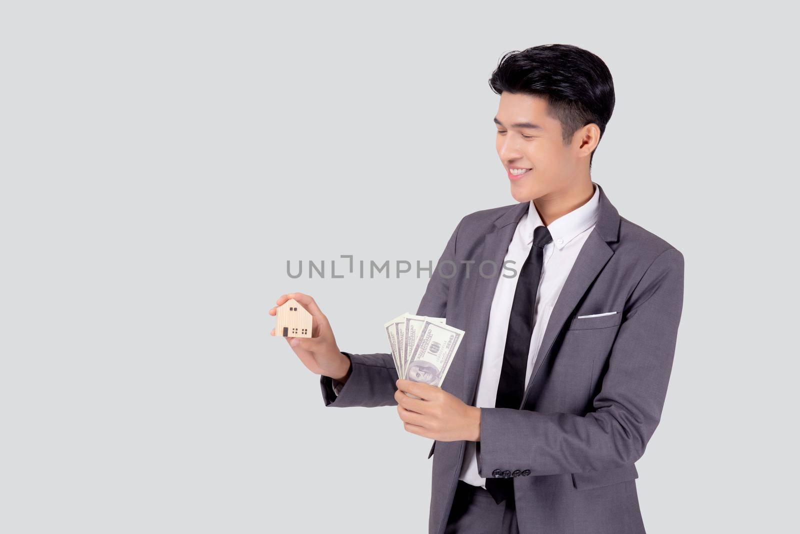 Young asian business man holding home and money dollar for saving for future, insurance agent and credit, debt and loan of finance, purchase home and refinance, investment about real property.