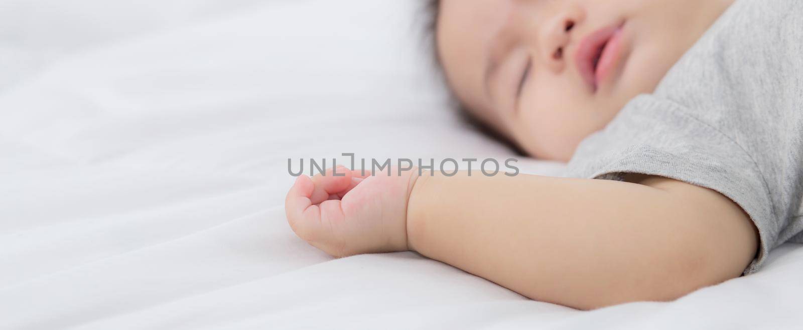 Portrait of asian little baby girl sleeping on bed in the bedroom at home, newborn napping with cozy and relax, infant innocence in bedtime, happy toddler cute, growth of child and emotion, indoors.