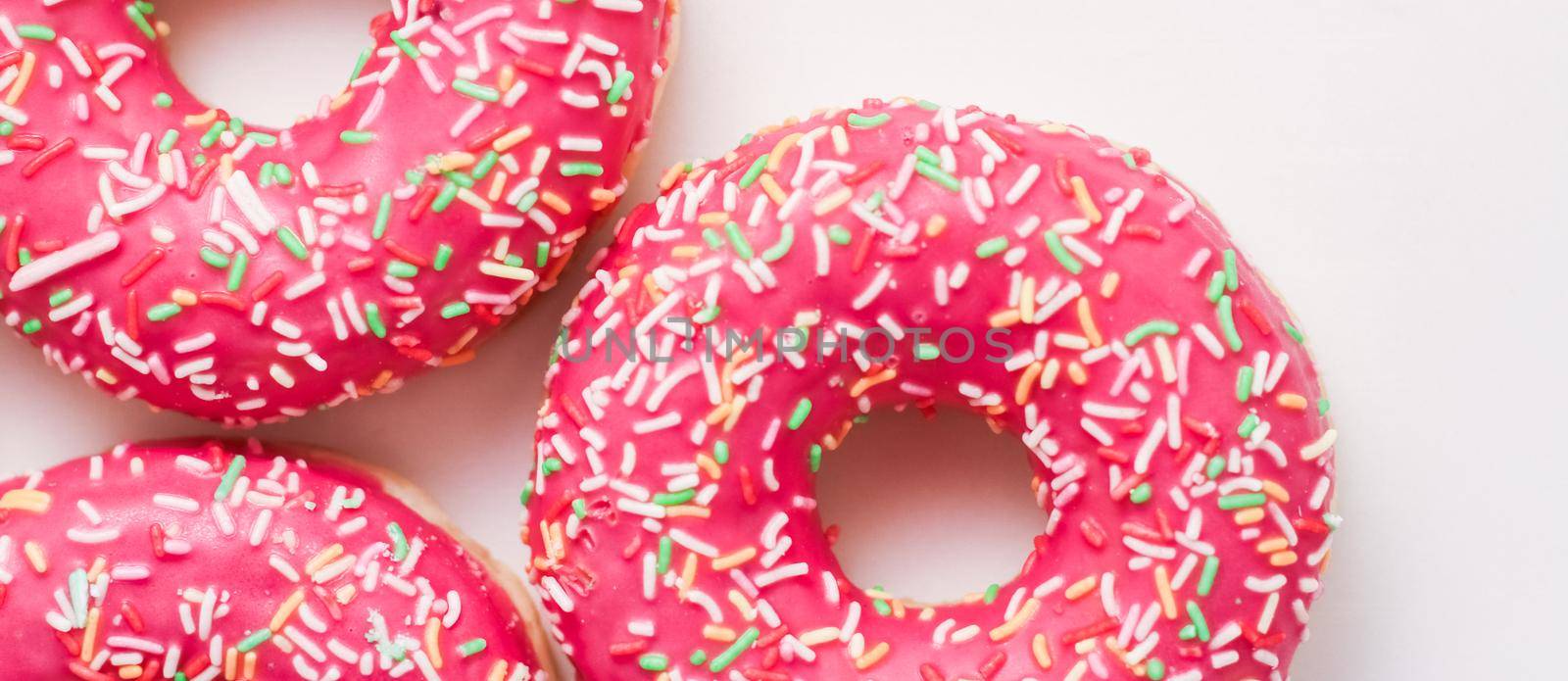 Bakery, branding and cafe concept - Frosted sprinkled donuts, sweet pastry dessert on marble table background, doughnuts as tasty snack, top view food brand flat lay for blog, menu or cookbook design