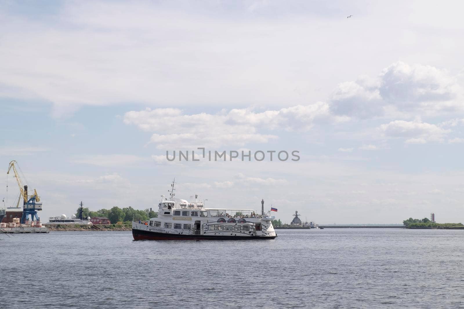 Kronshtadt, St. Petersburg, Russia - June 06, 2021 A pleasure boat with tourists arrives at the pier in the harbor. Selective focus.