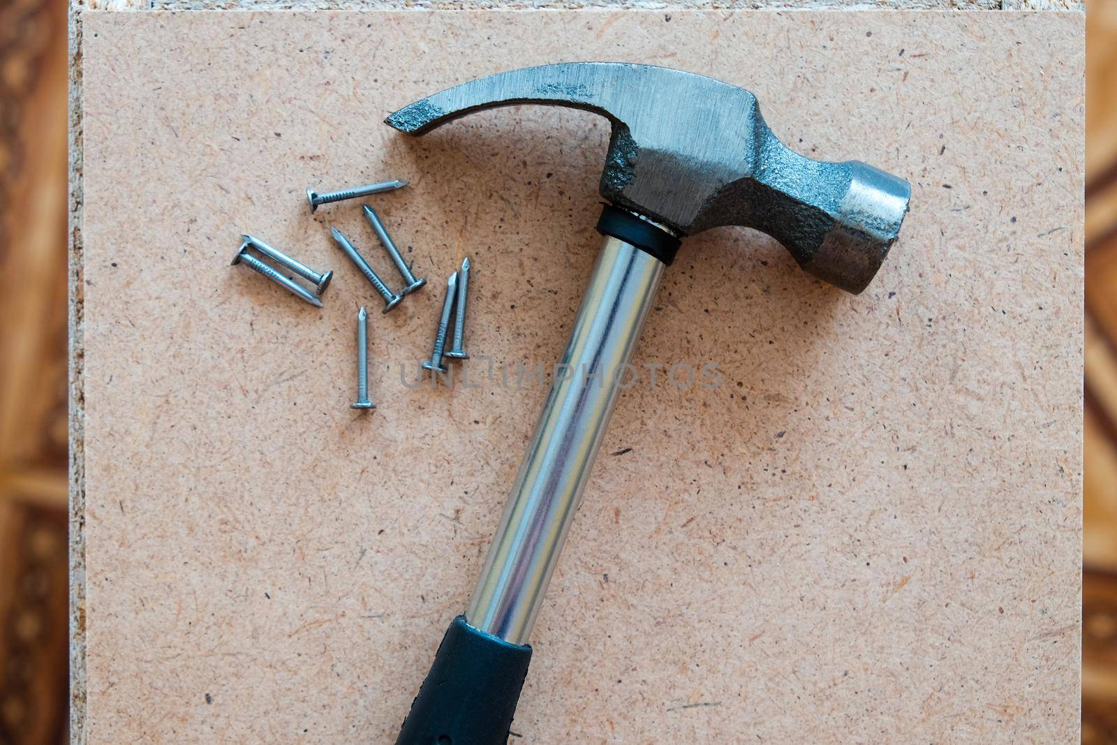 Iron hammer and nails on plywood. wood background.
