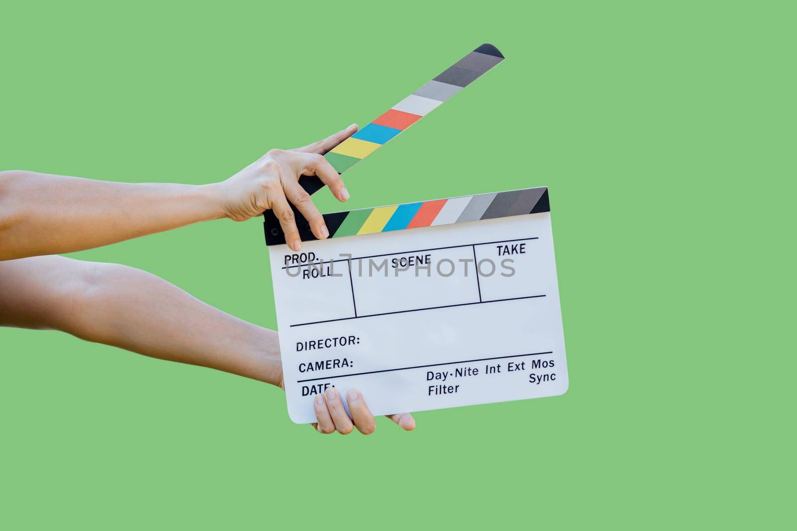 Hand holding film slate colors board for movie cinema and television industry on green background by wattanaphob