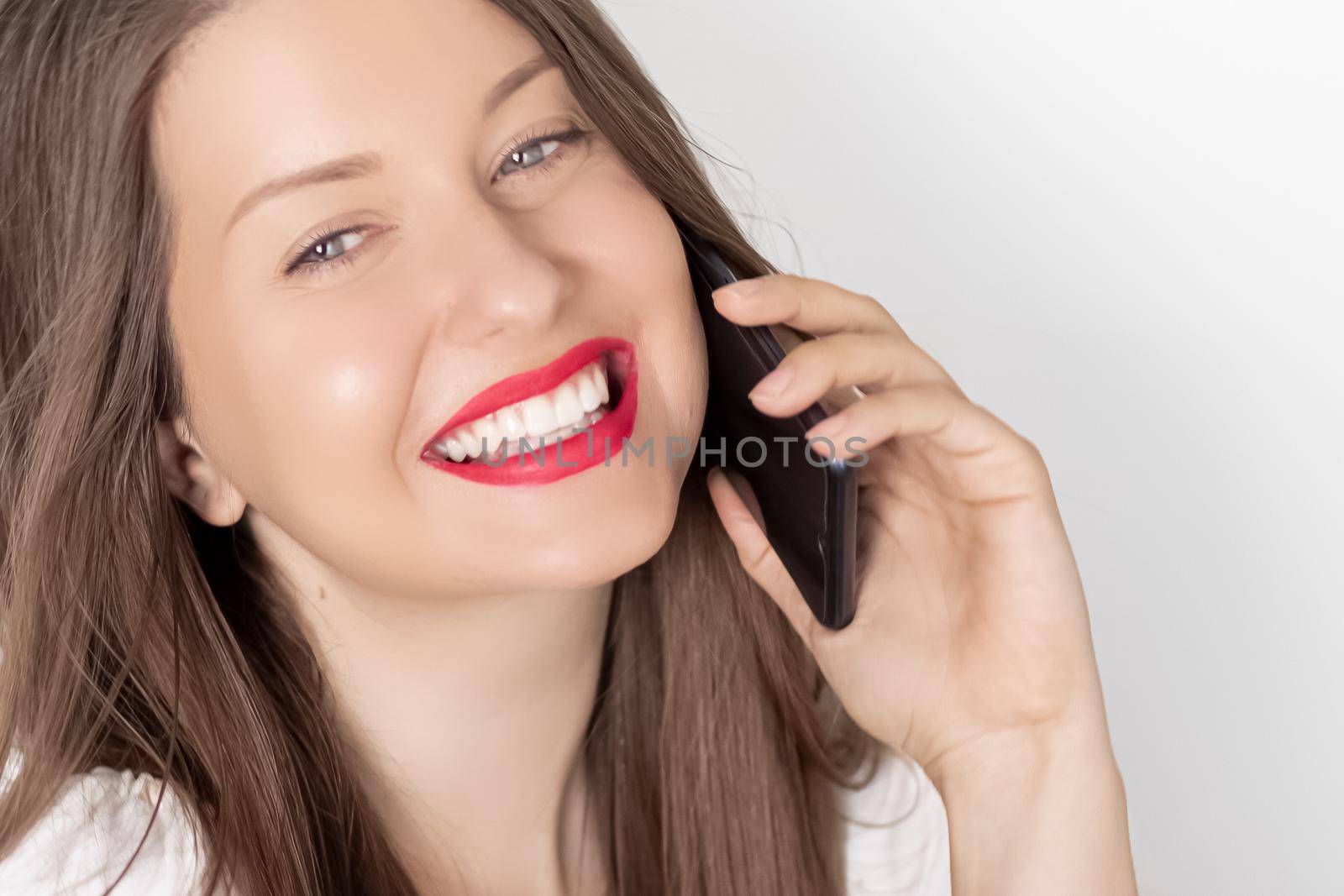 Happy smiling woman calling on smartphone, portrait on white background. People, technology and communication concept by Anneleven