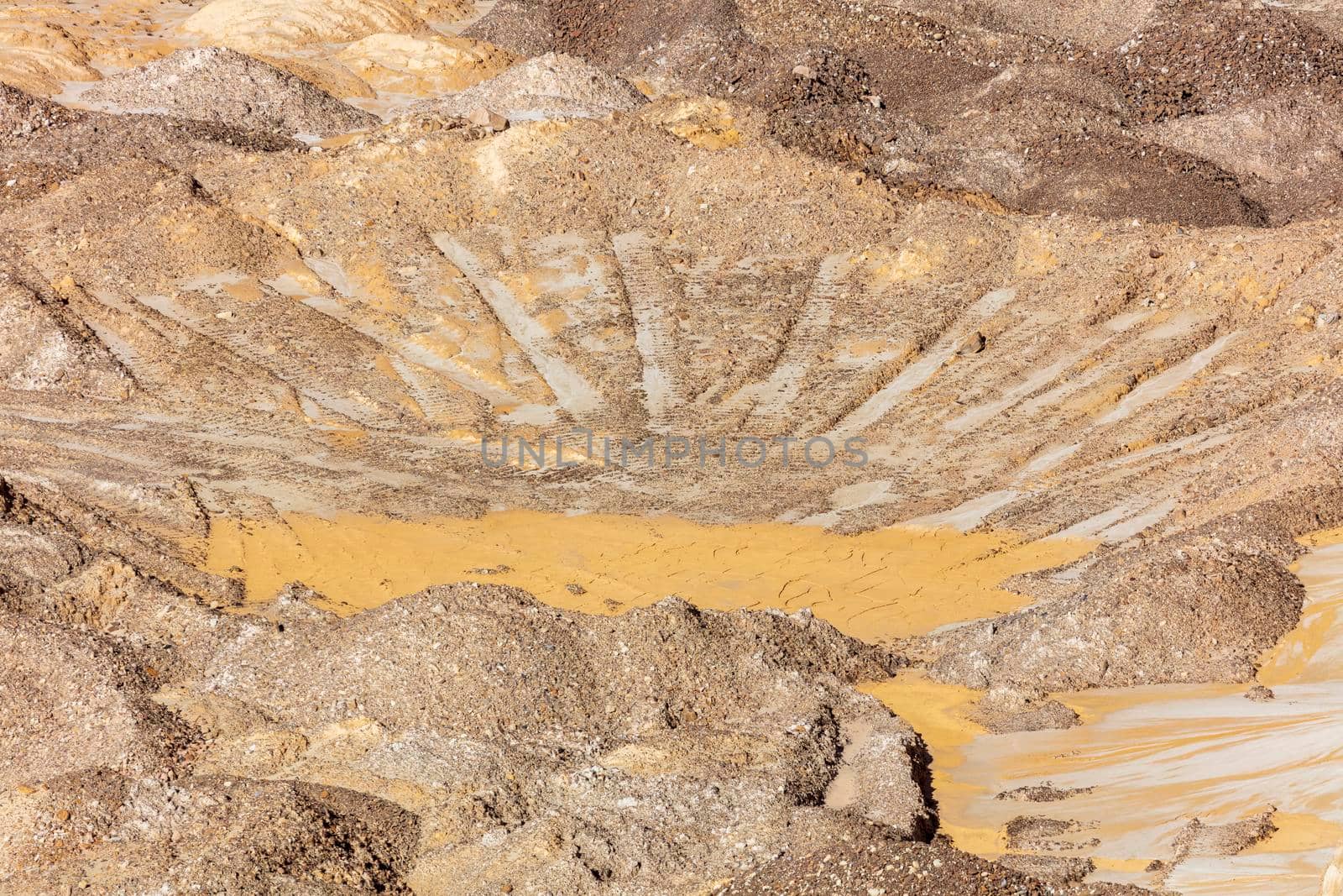 Photograph of crushed sand and stone laying on the ground in a large quarry