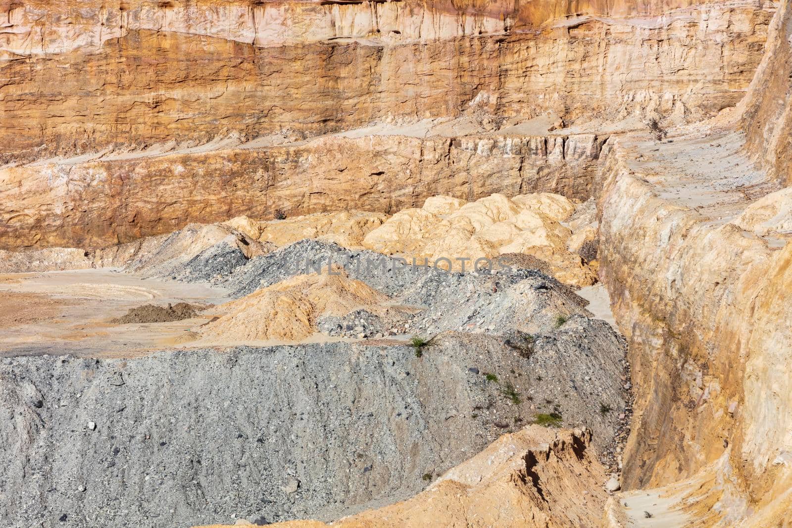 Photograph of crushed sand and stone laying on the ground in a large quarry