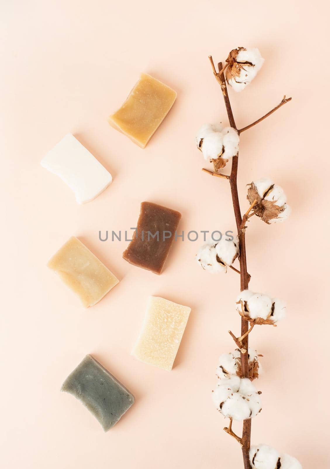 Natural cosmetics. composition with various soap and cotton branch, natural cosmetics on beige background, top view flat lay