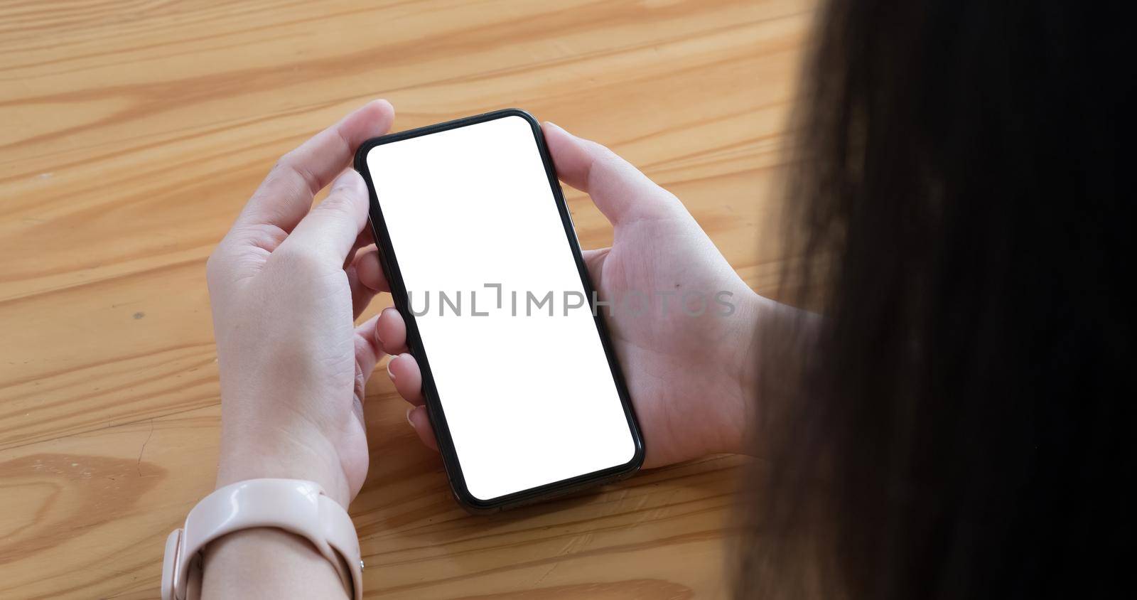 Top view Woman sitting and holding blank screen mock up mobile phone.