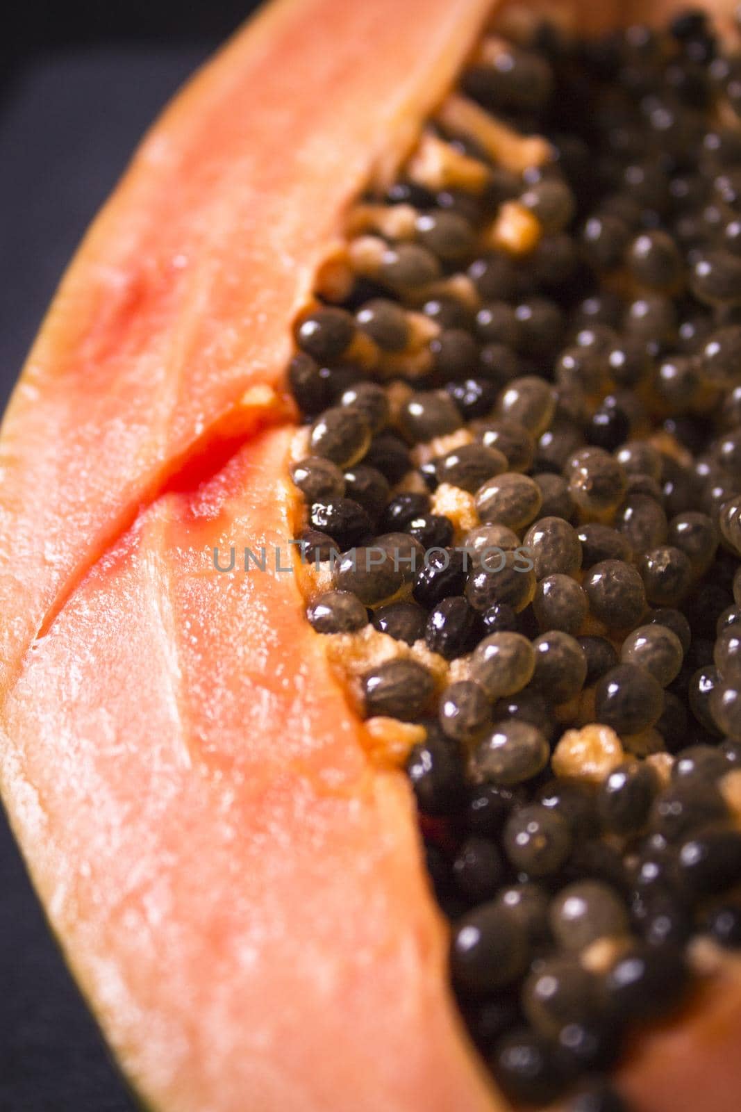 Half of an open papaya with the seeds. No people