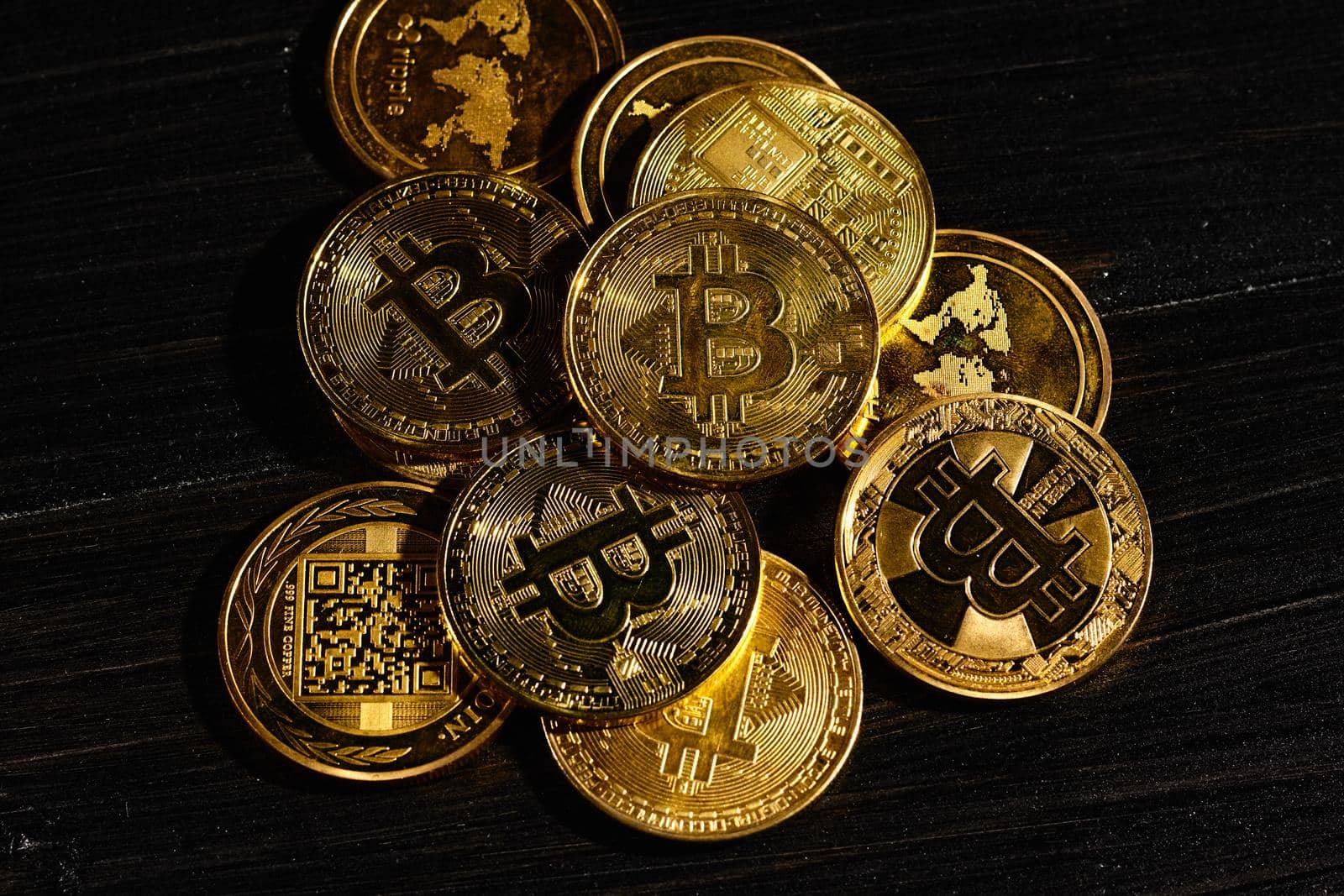 Leader in cryptocurrency bitcoin BTC on a top of coins against black wooden surface. Closeup golden coin with bitcoin logo. Stack of decentralized digital currency. Crypto payment. Electronic money