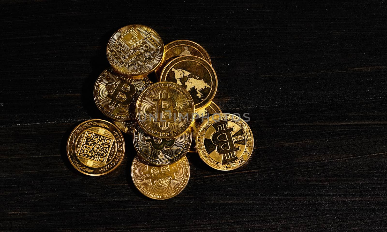 Leader in cryptocurrency bitcoin BTC on a top of coins against black wooden surface. Closeup golden coin with bitcoin logo. Stack of decentralized digital currency. Crypto payment. Electronic money