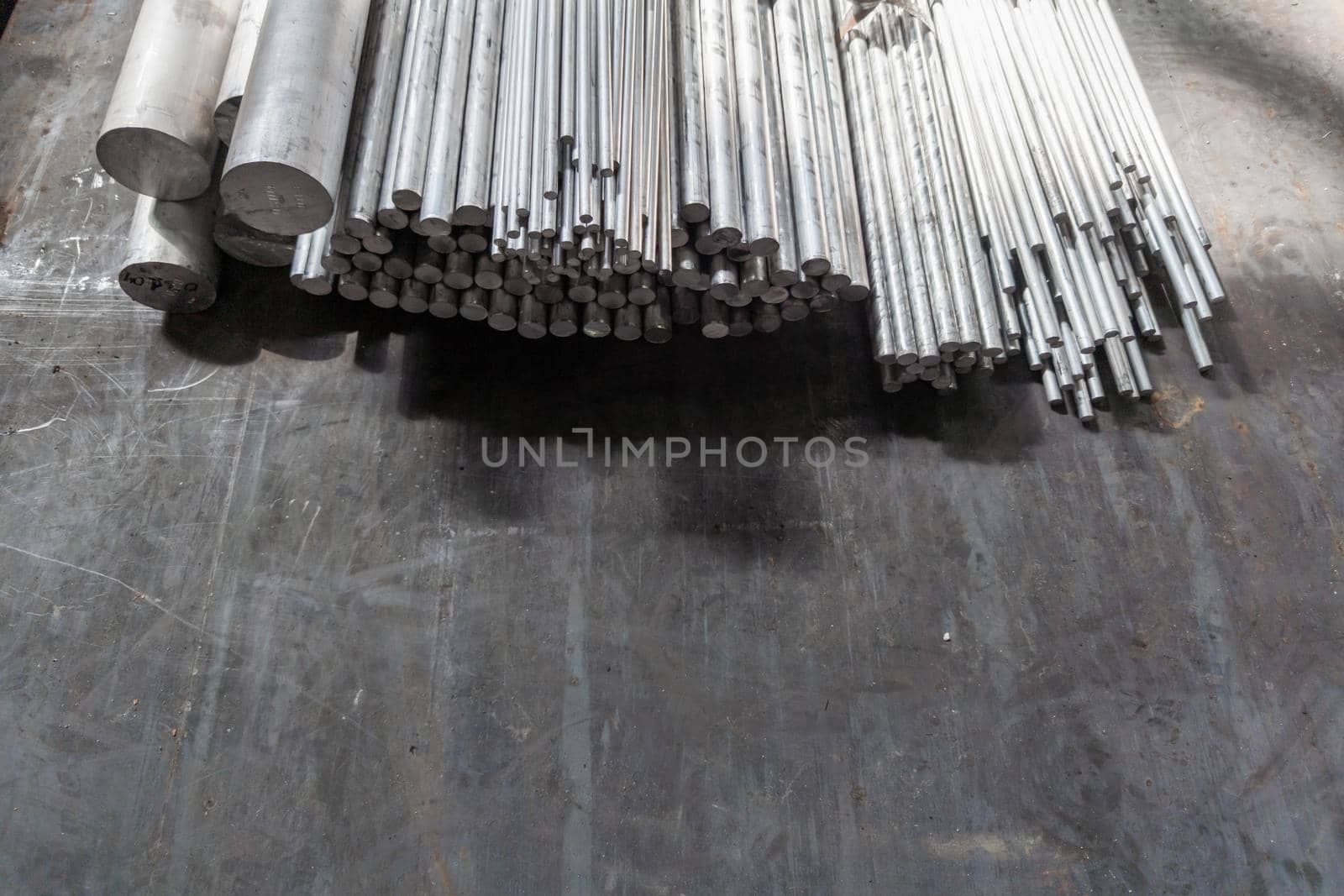 aluminium round long products on black steel surface.