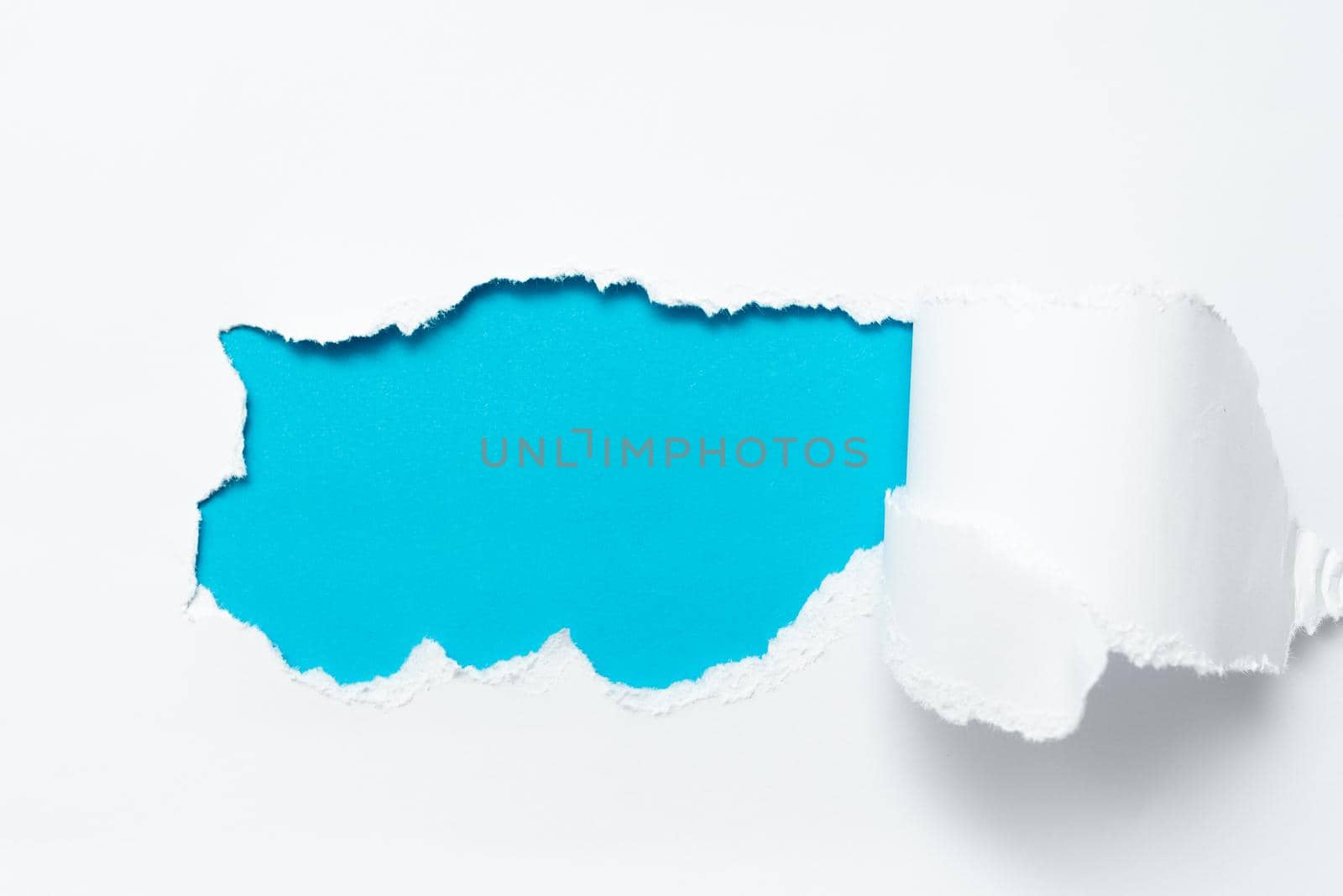 Tear on sheet reveals background behind the front side