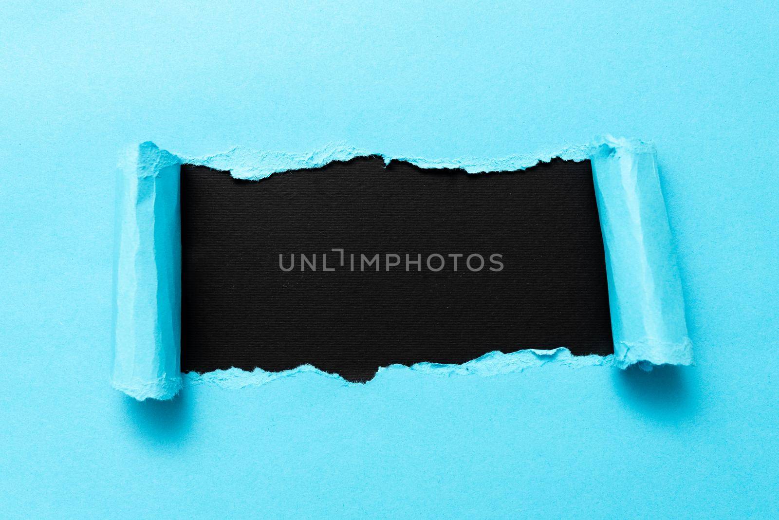 Tear on sheet reveals background behind the front side