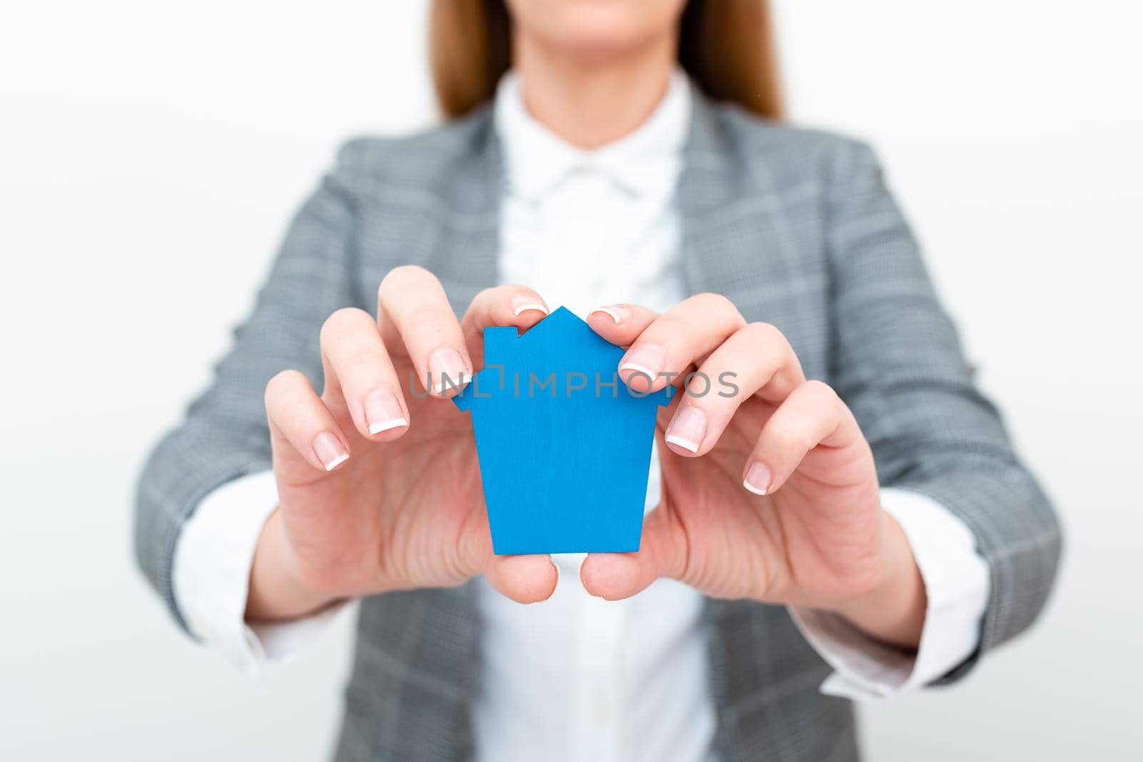 A Young Lady Businesswoman Holding Presenting Home In Business Outfit