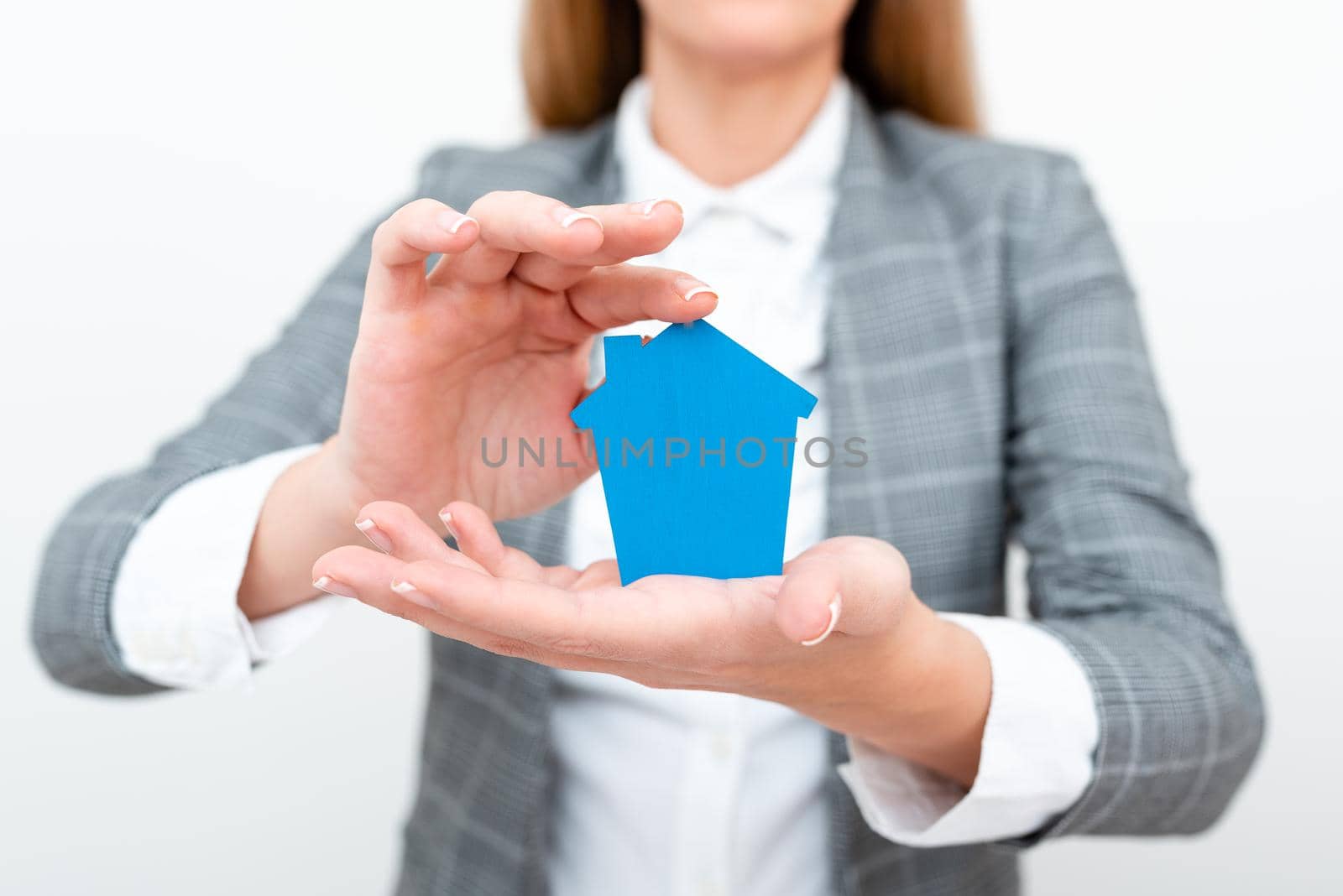 A Young Lady Businesswoman Holding Presenting Home In Business Outfit