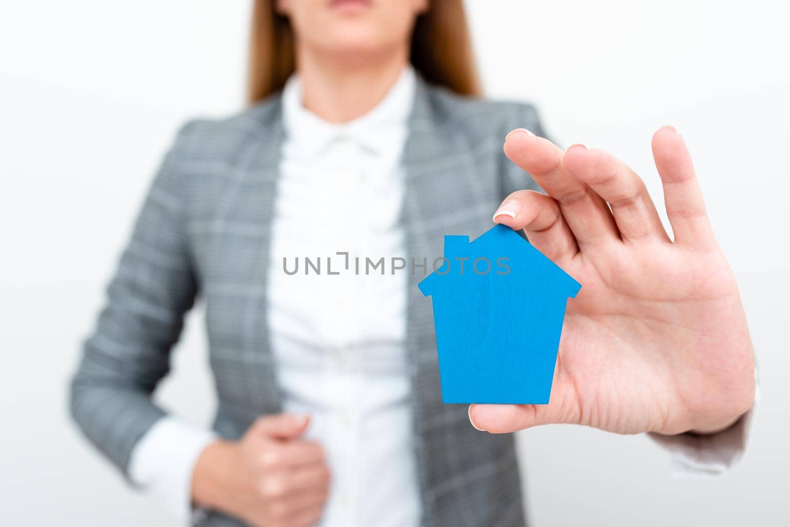 A Young Lady Businesswoman Holding Presenting Home In Business Outfit