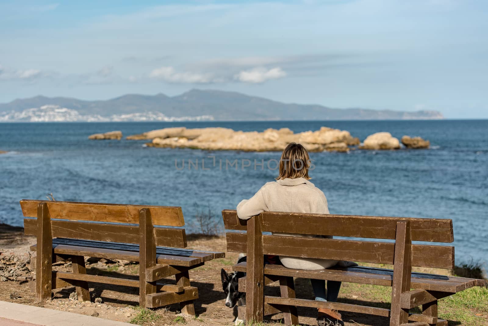 SANT MARTI DE AMPURIES, GIRONA, SPAIN : 2020 08 FEB : YOUNG BLONDE WOMAN IN THE Platja de Les Muscleres in La Escala behind the ruins of Empuries, in the Province of Giron, Catalonia, Spain.