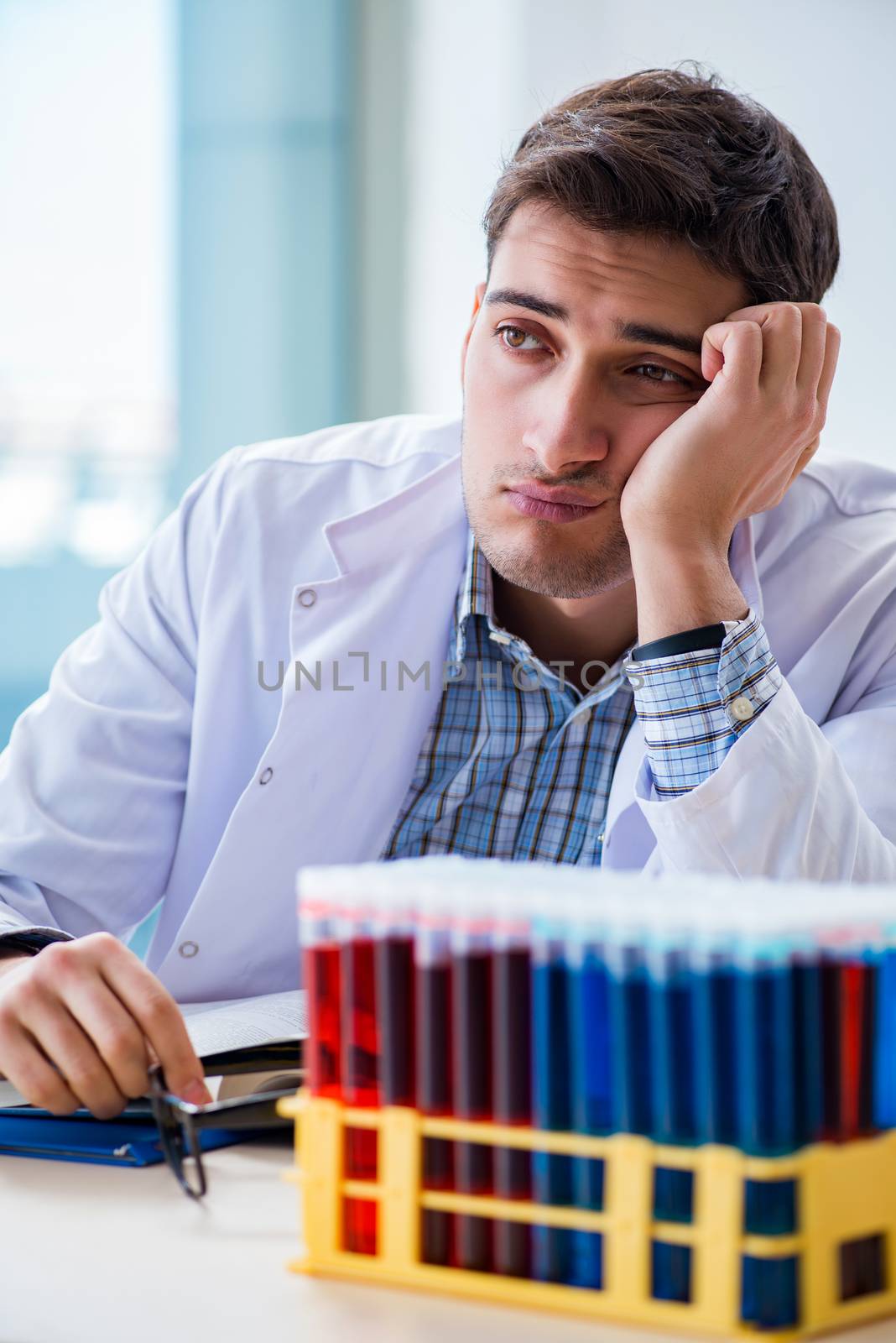 Young chemist student working in lab on chemicals