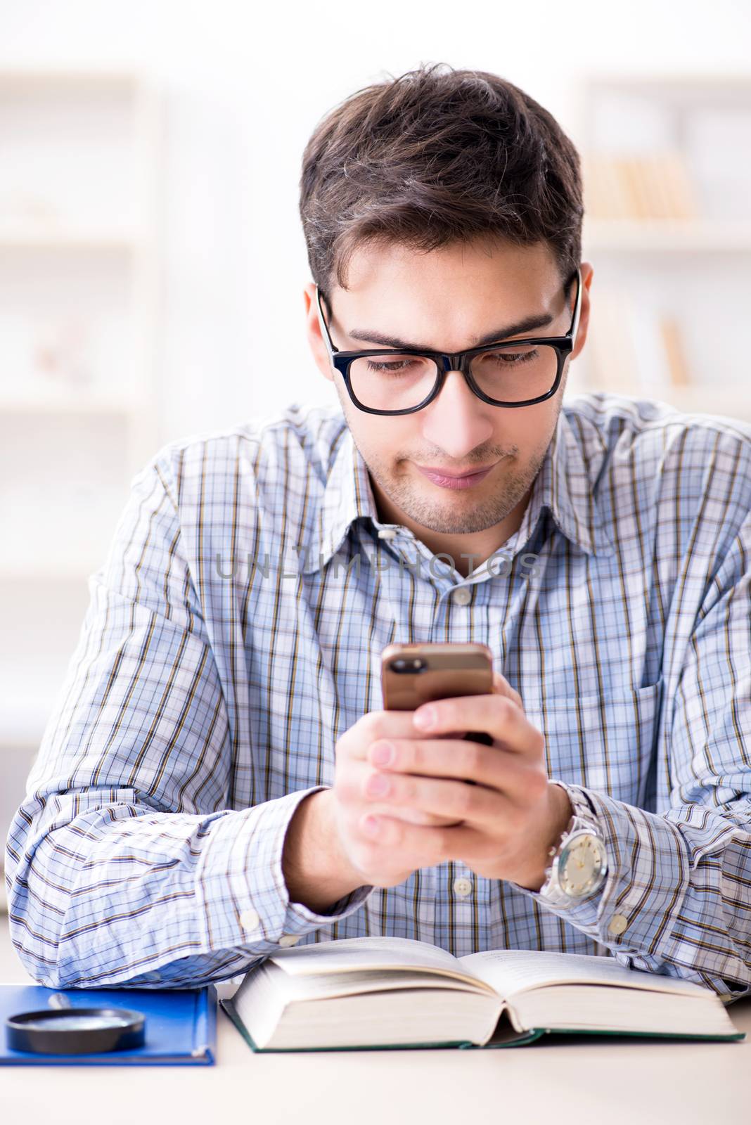 Young student texting while sitting in classroom