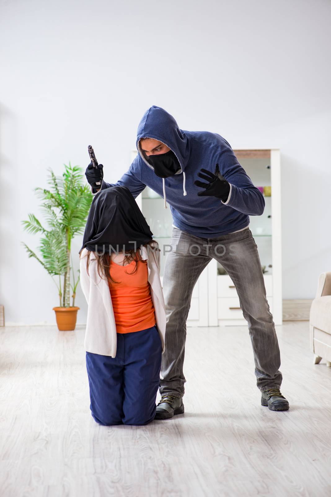 Armed man assaulting young woman at home