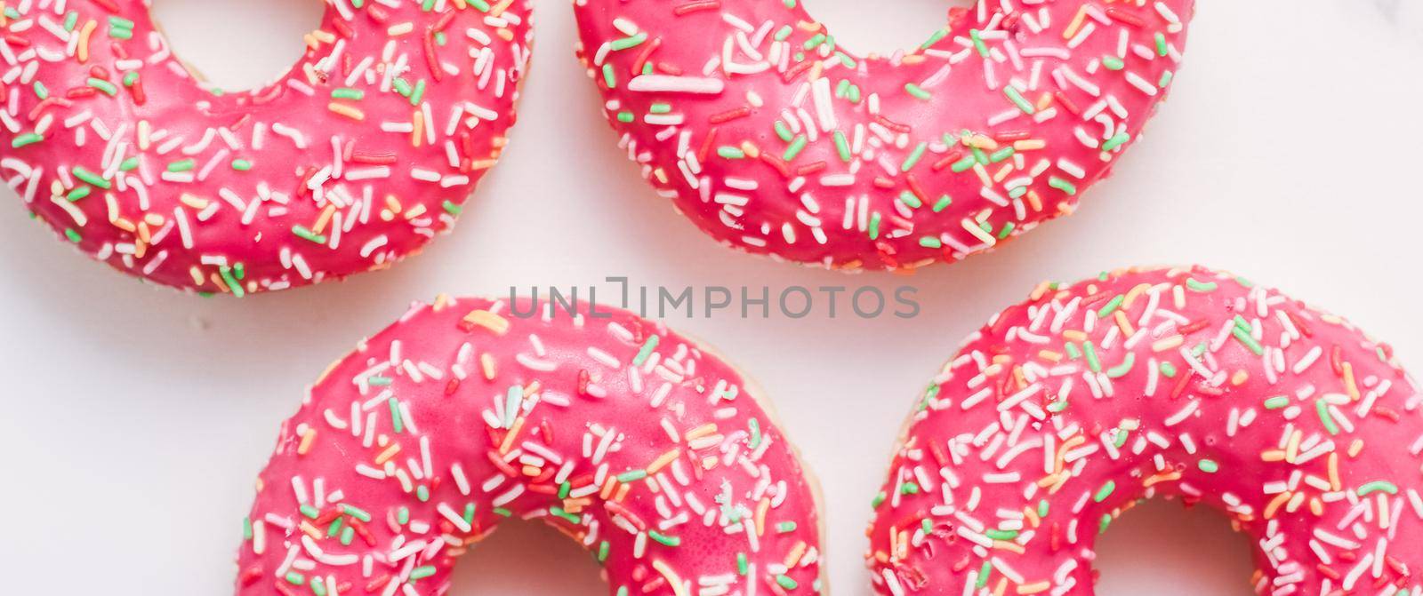 Bakery, branding and cafe concept - Frosted sprinkled donuts, sweet pastry dessert on marble table background, doughnuts as tasty snack, top view food brand flat lay for blog, menu or cookbook design