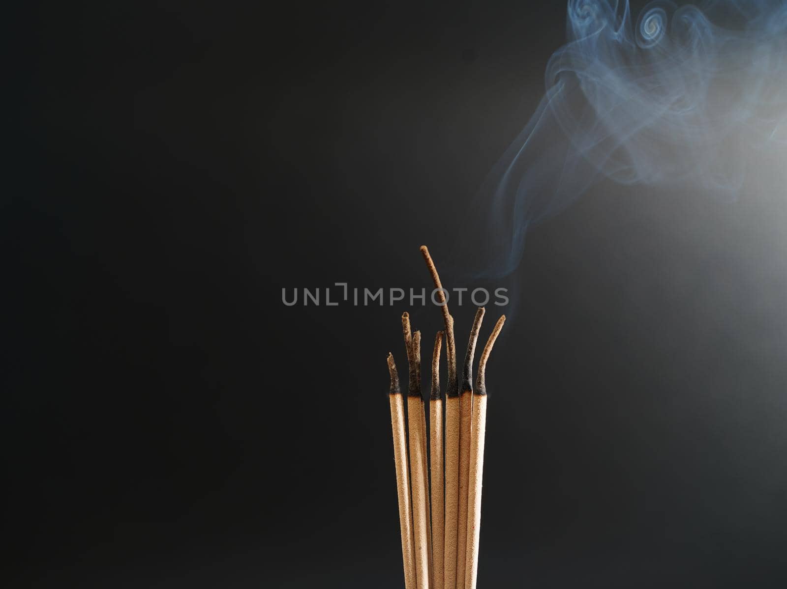Burning incense white smoke black background used as a worship background image a sacred object of Buddhist beliefs focus on the smoke by noppha80