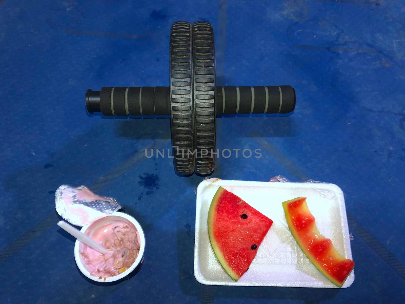 Yogurt and watermelon Upper-specific exercise rolling wheel blue yoga mat sectional exercise concept And healthy eating. by noppha80
