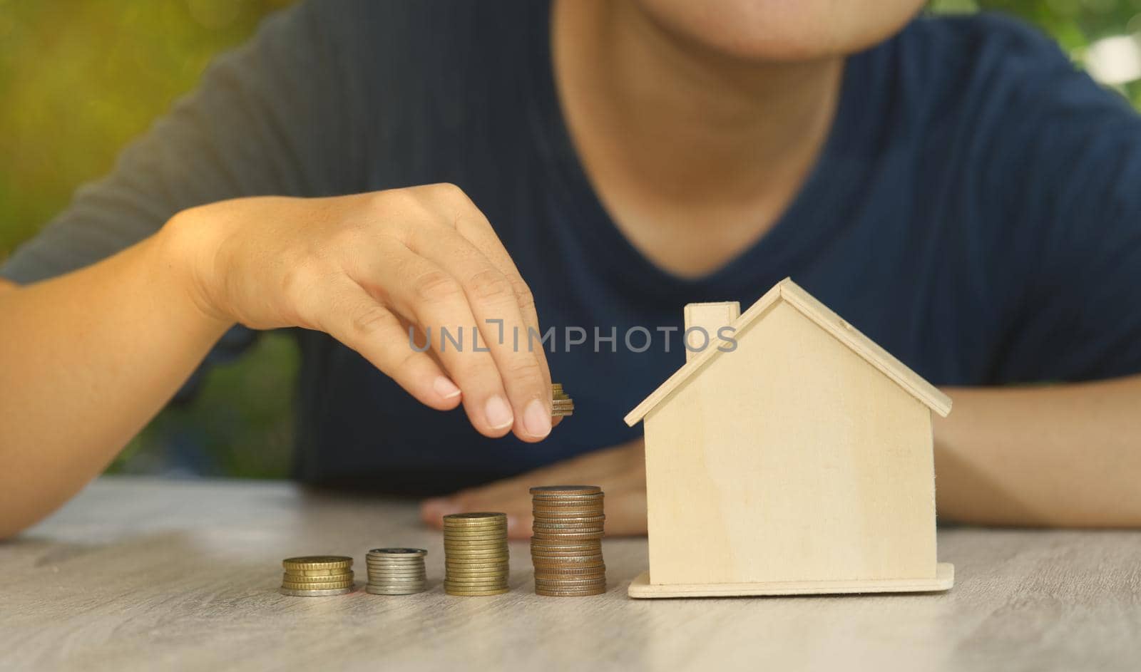Abstract Investor puts coins stacked on the desk with mockup house concept auction value real estate investment wealth financial investment and business income growth.