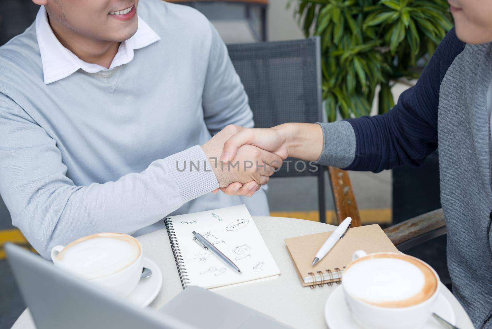 Business talk and hands shake at a coffee shop