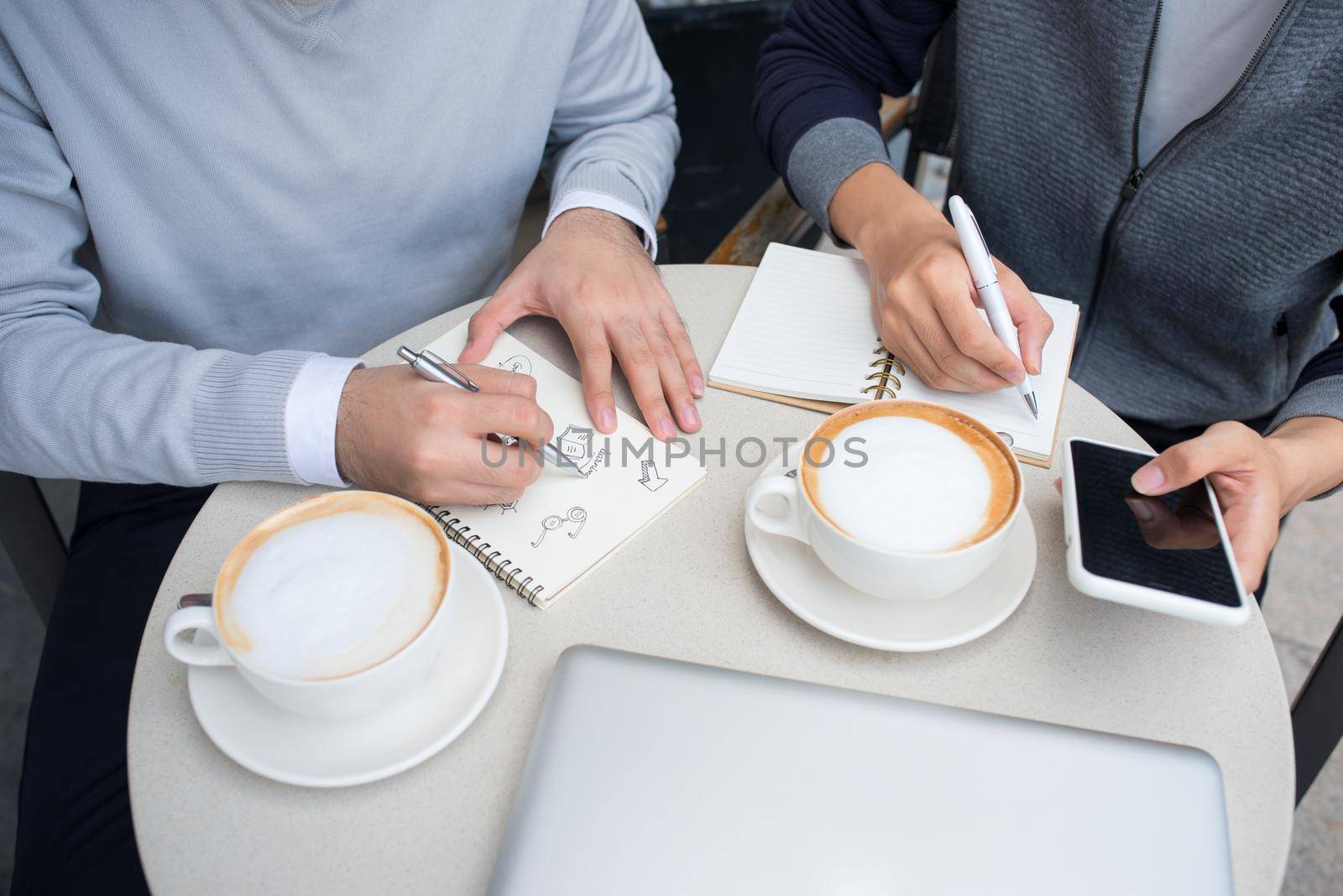 Two cheerful asian business people discussing with documents