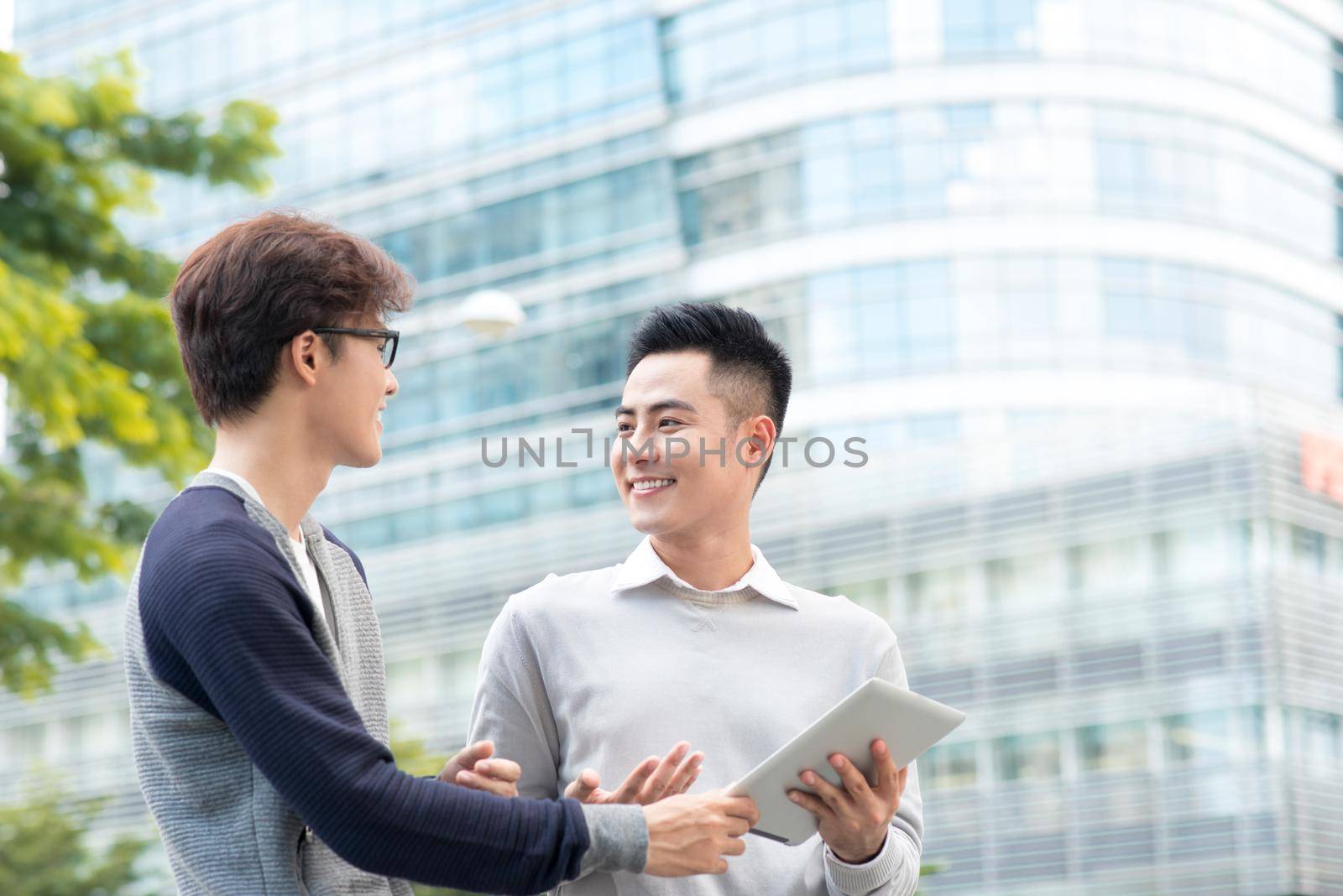 Asian business people discussing information on tablet computer