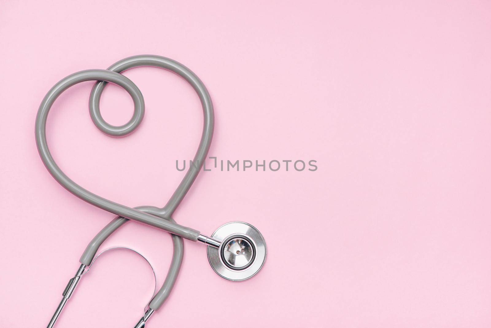 Medical concept. The stethoscope with heart shape on pink background. by makidotvn