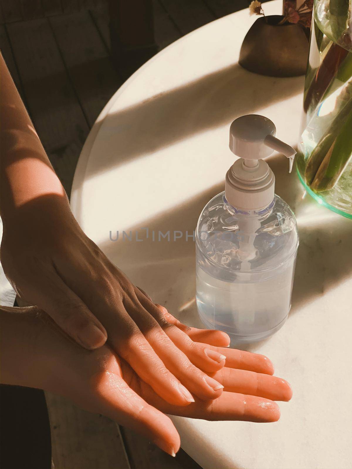 Hand of woman pressing alcohol gel from bottle and applying sanitizer gel for hand wash to make cleaning and clear germ. by Benzoix