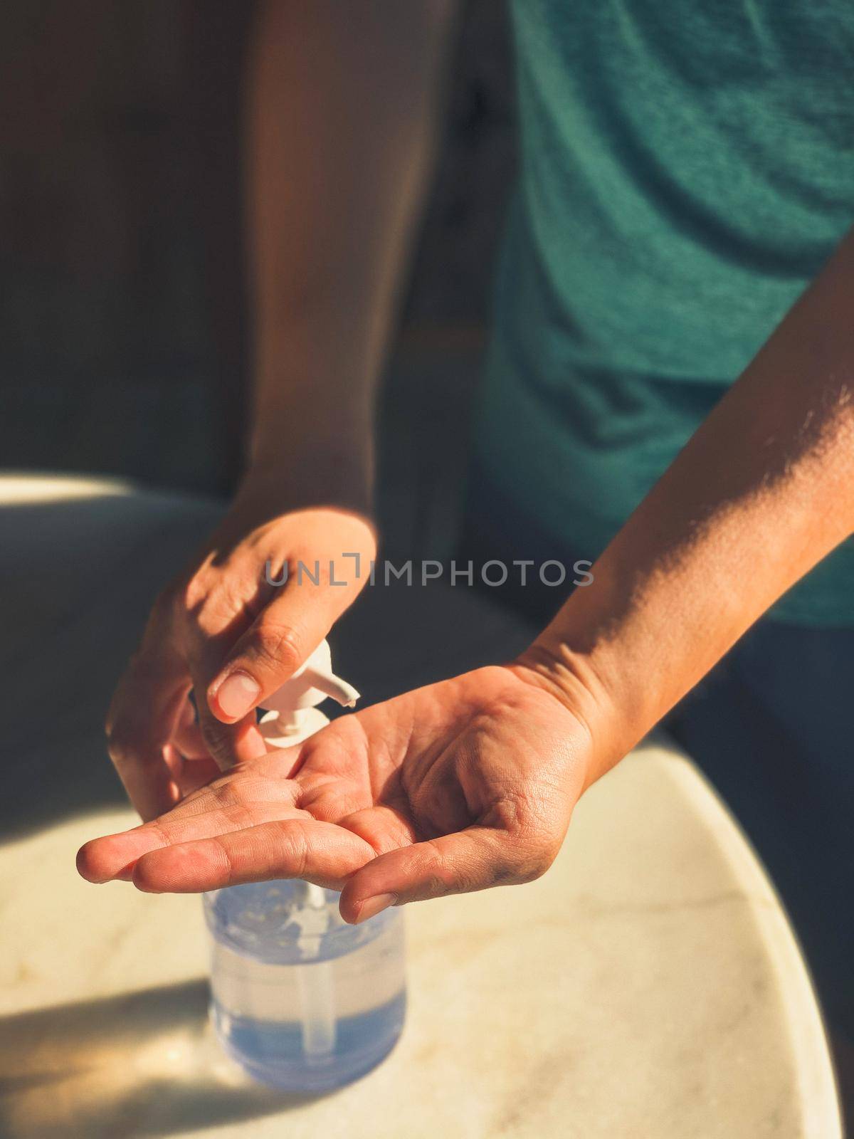 Hand of woman pressing alcohol gel from bottle and applying sanitizer gel for hand wash to make cleaning and clear germ. by Benzoix