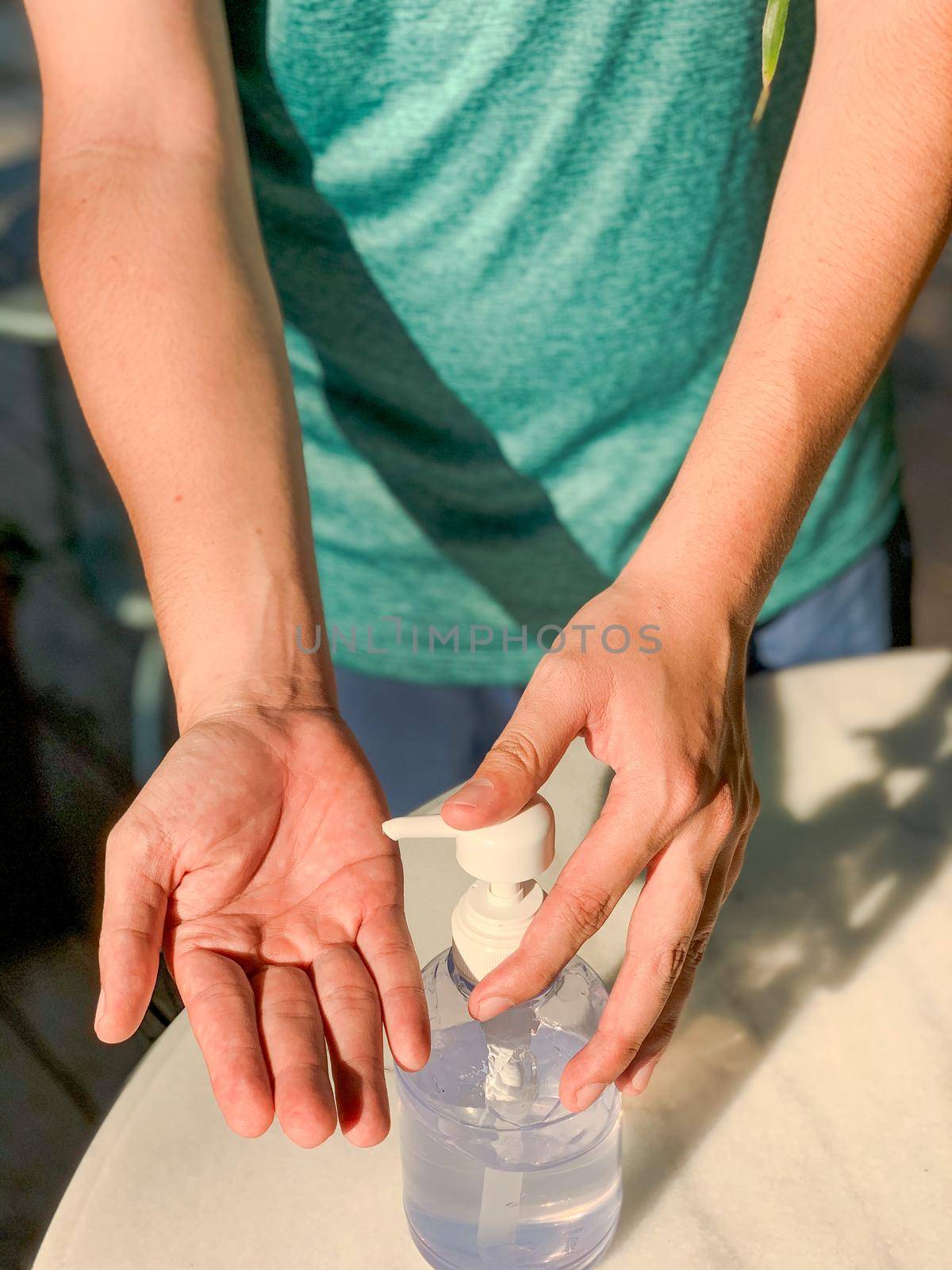 A man hands using wash hand sanitizer gel pump dispenser. Washing hand with Alcohol Sanitizer, prevent the virus and bacterias,Hygiene concept. by Benzoix