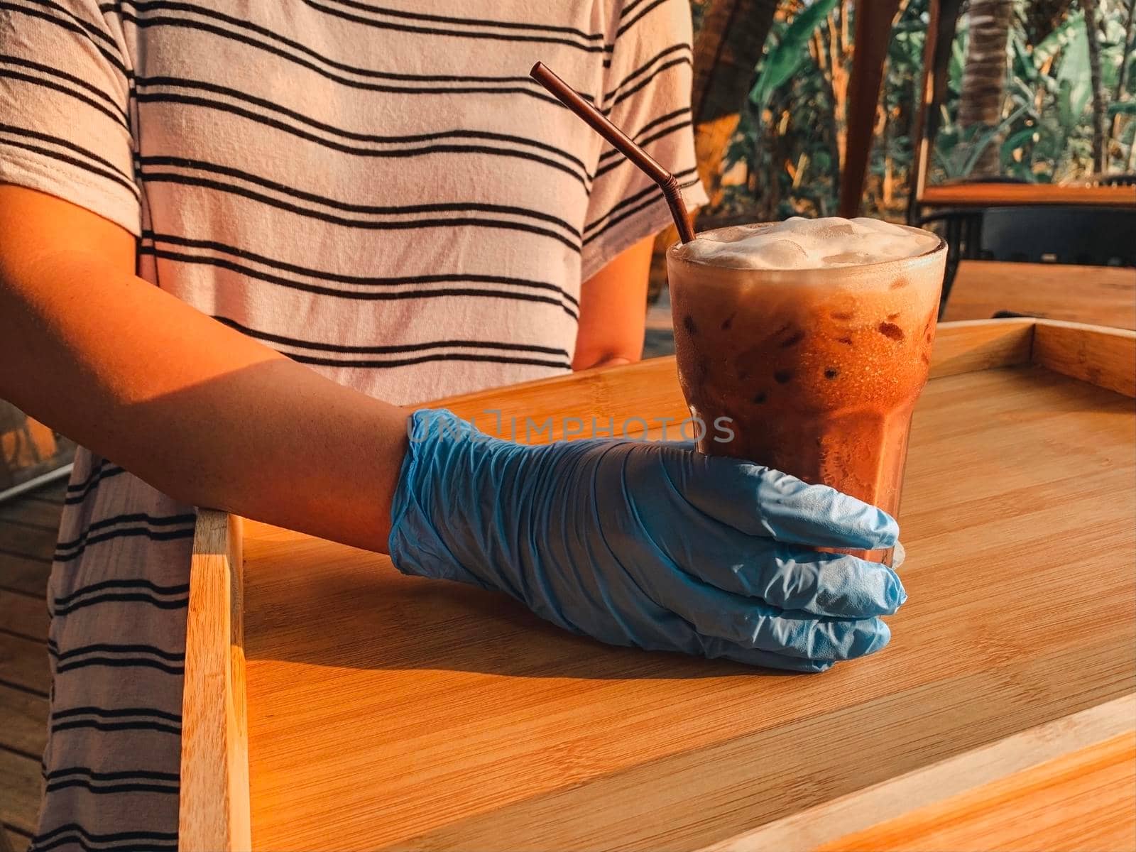 Waitresses holding tray with glasses of Thai Tea. Coronavirus situation.