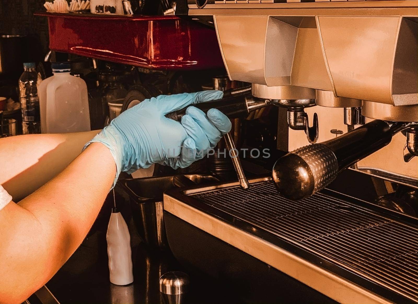 Barista holding portafilter making espresso coffee at the cafe at the coffee machine. Coronavirus situation